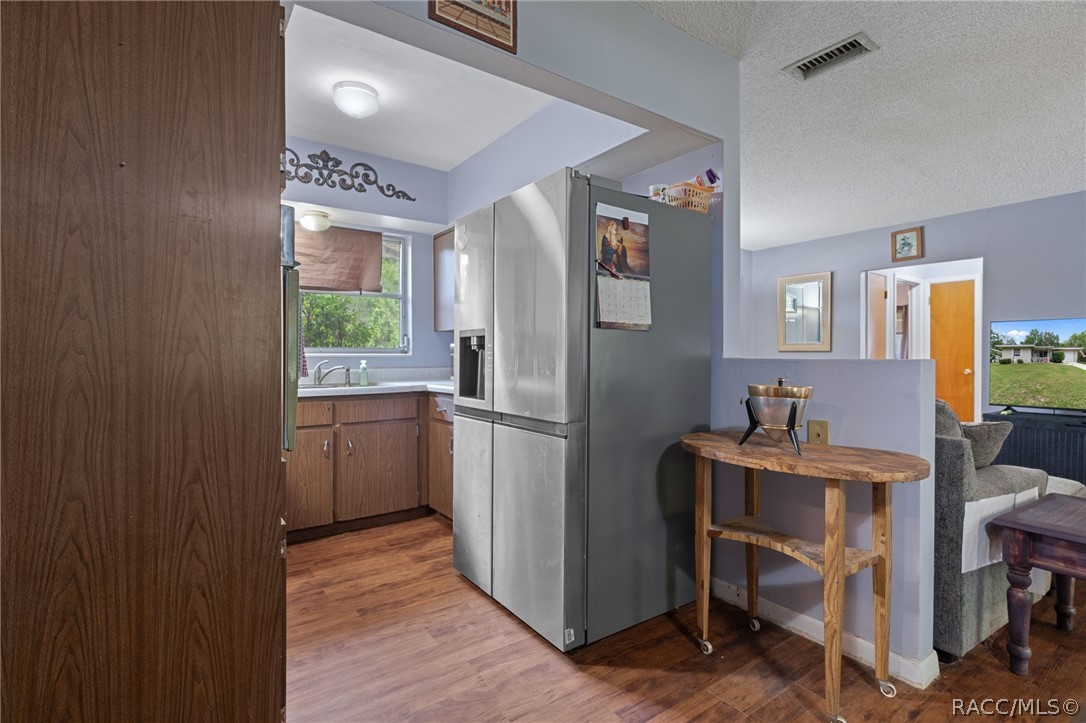 3355 South Highlands Avenue Inverness, FL 34452 - Photo 11 of 30 a kitchen with a refrigerator a sink and dishwasher with wooden floor
