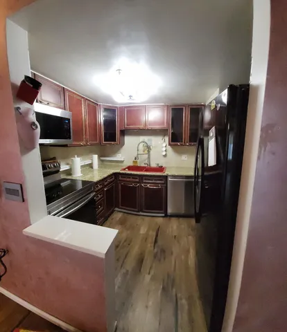 a kitchen with stainless steel appliances a sink stove and refrigerator