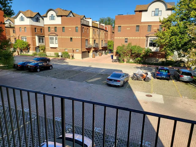 a view of building with cars parked across