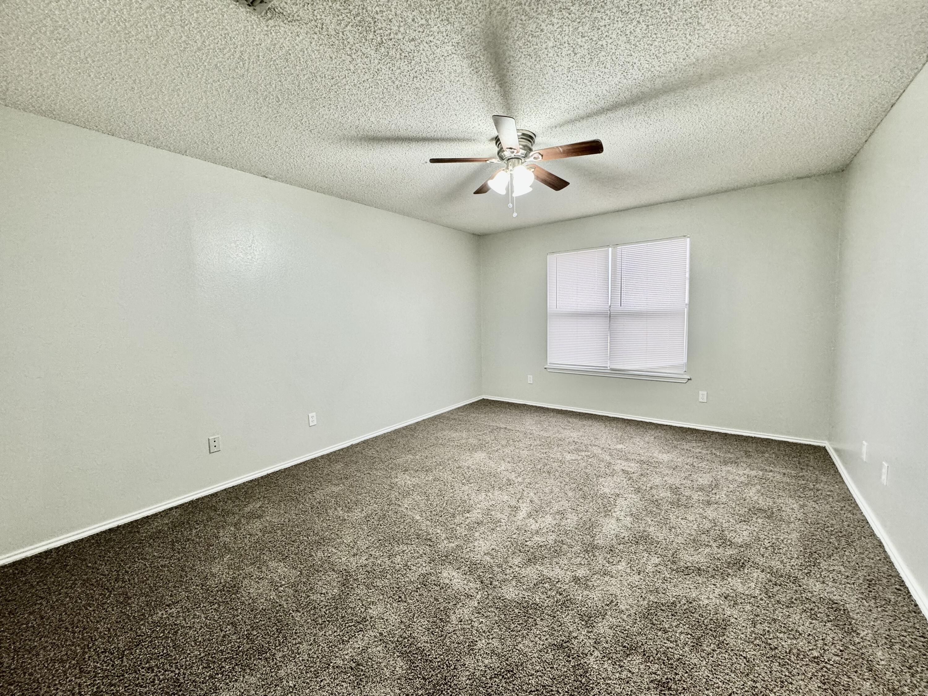 1003 Juneau Avenue Lubbock, TX 79416 - Photo 11 of 21 an empty room with a window and ceiling fan