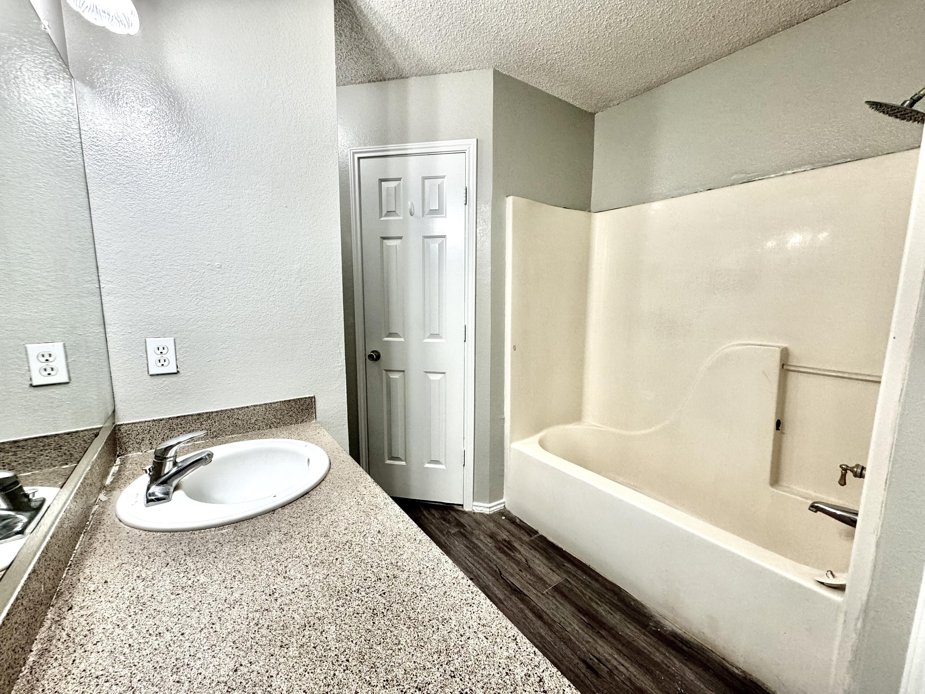 1003 Juneau Avenue Lubbock, TX 79416 - Photo 12 of 21 a bathroom with a tub sink and mirror