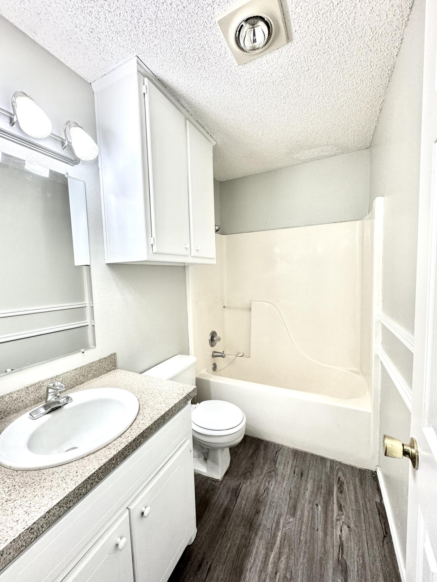 1003 Juneau Avenue Lubbock, TX 79416 - Photo 14 of 21 a bathroom with a sink a toilet and a large mirror