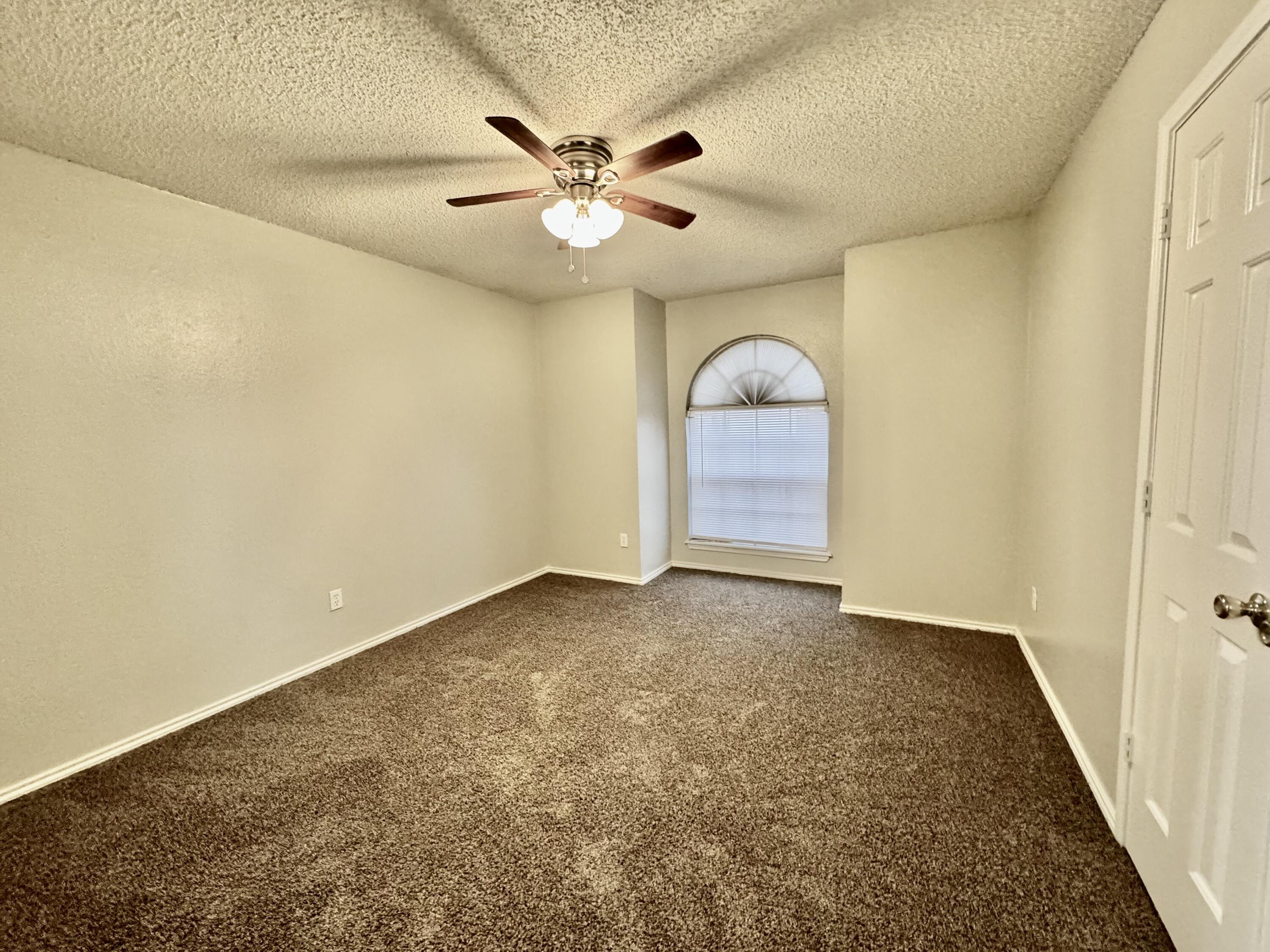 1003 Juneau Avenue Lubbock, TX 79416 - Photo 15 of 21 an empty room with a ceiling fan and carpet