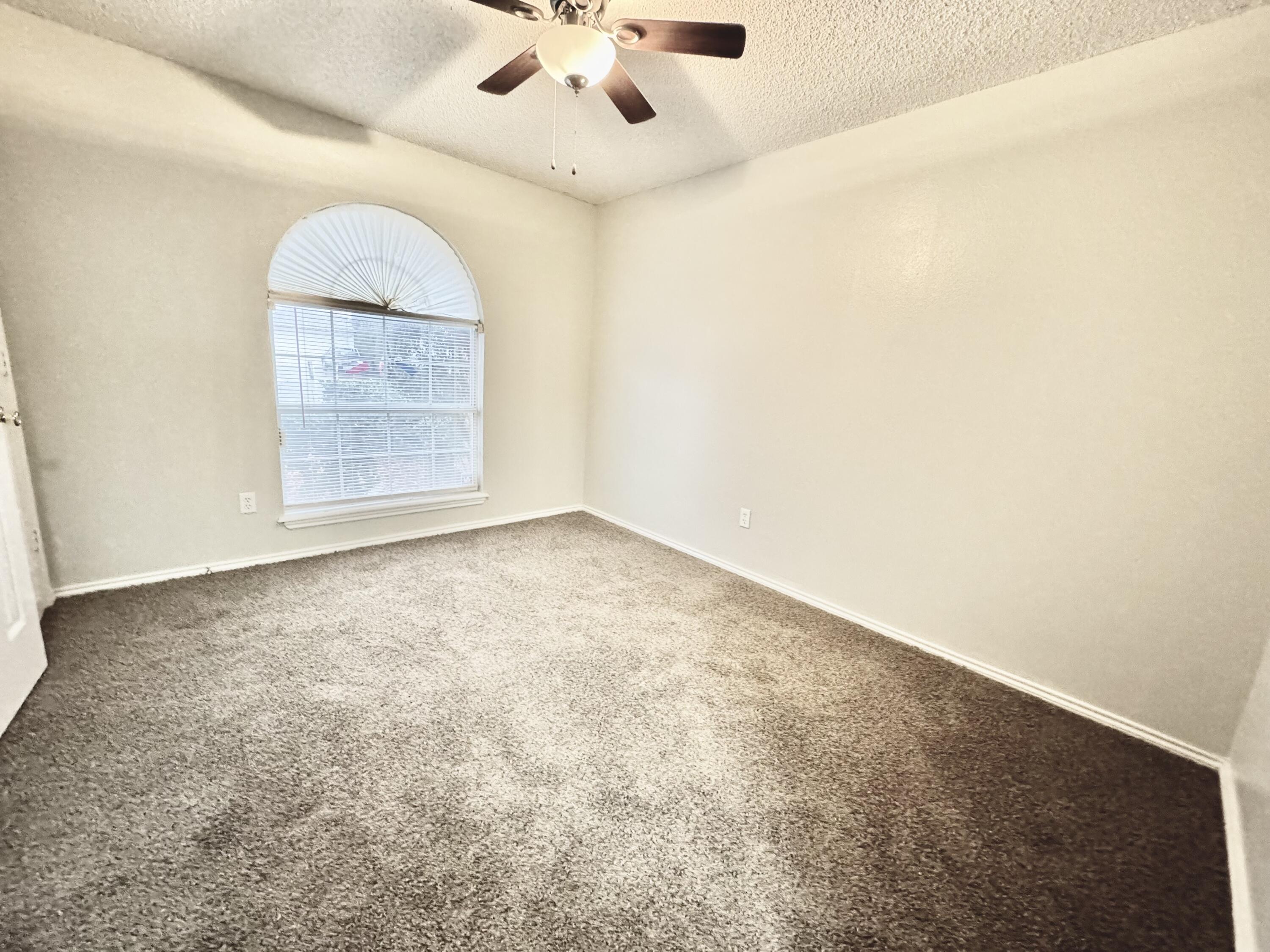 1003 Juneau Avenue Lubbock, TX 79416 - Photo 16 of 21 an empty room with a ceiling fan and window