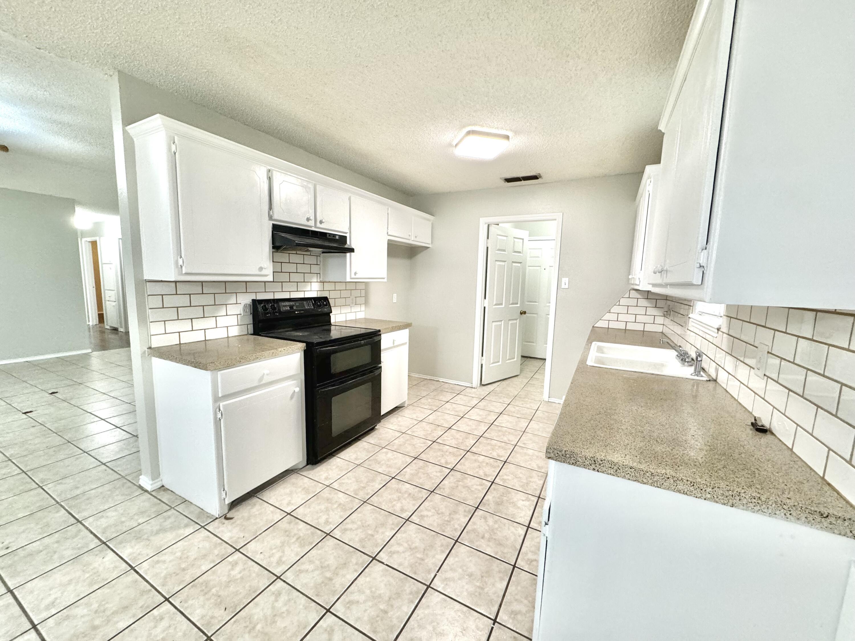 1003 Juneau Avenue Lubbock, TX 79416 - Photo 8 of 21 a kitchen with stainless steel appliances granite countertop a stove a sink and a refrigerator