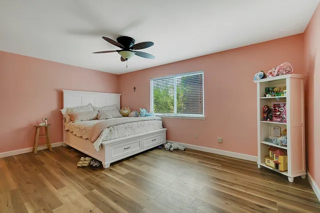 a bedroom with a bed and wooden floor