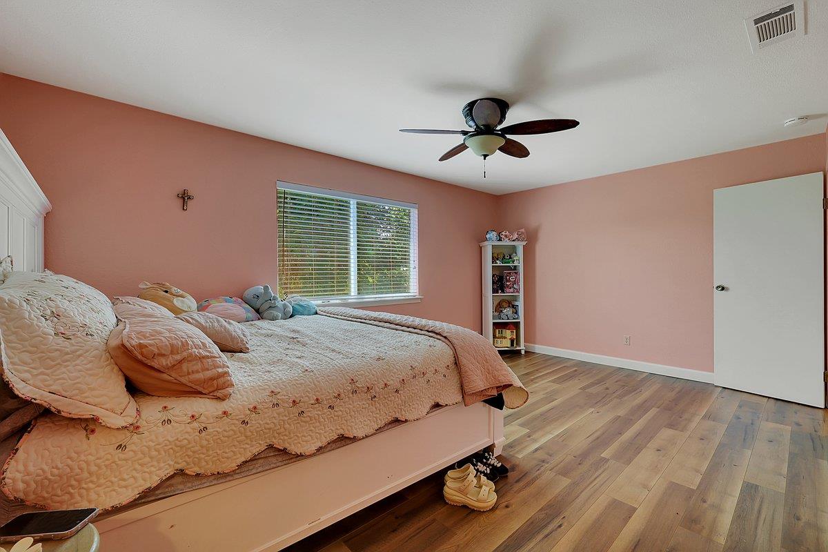 10307 Alta Mesa Road Wilton, CA 95693 - Photo 16 of 58 a bedroom with a bed and wooden floor