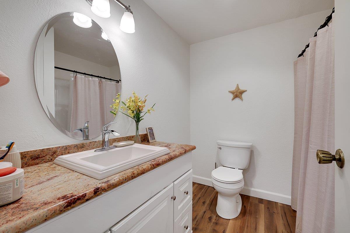 10307 Alta Mesa Road Wilton, CA 95693 - Photo 26 of 58 a bathroom with a granite countertop toilet sink and mirror