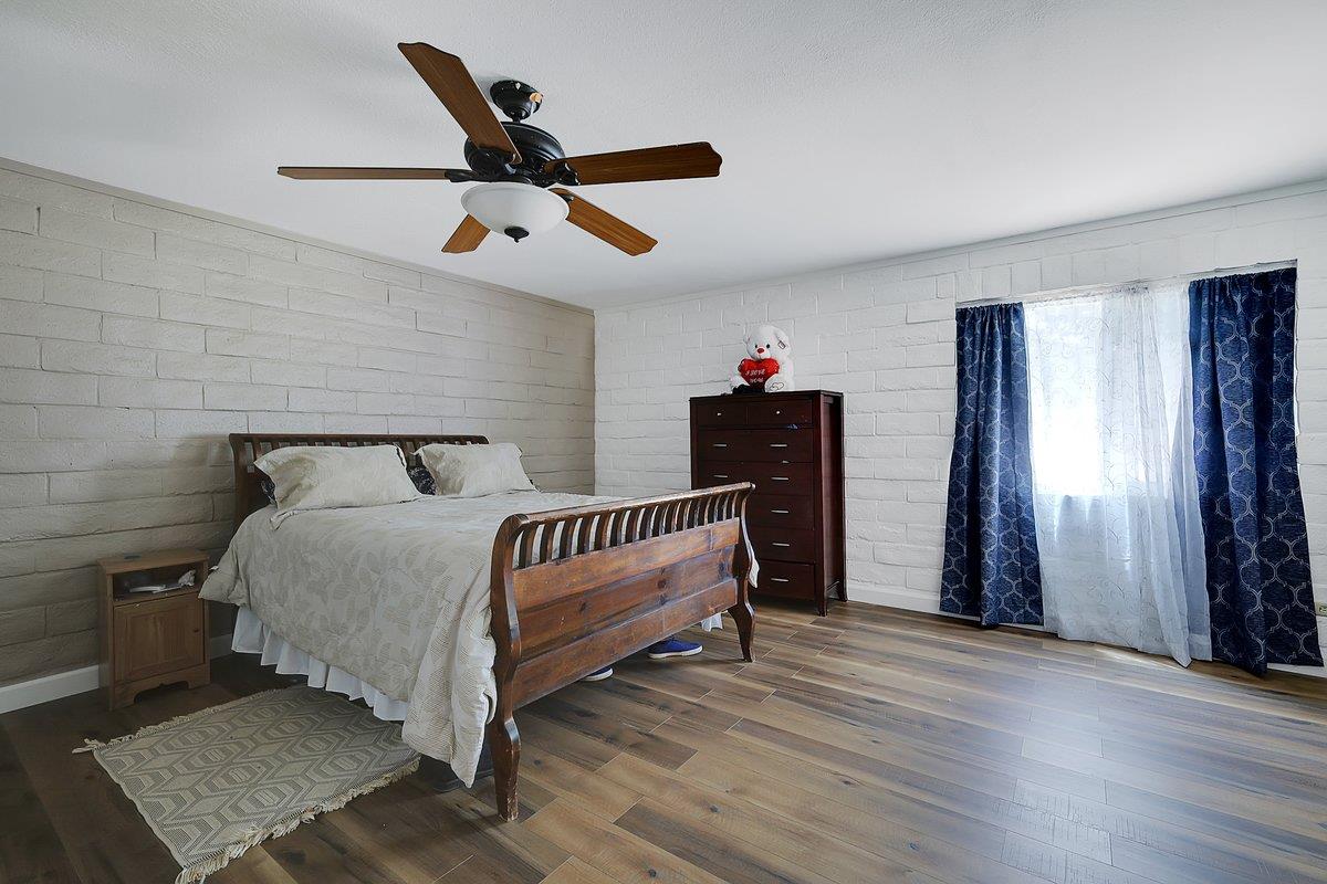 10307 Alta Mesa Road Wilton, CA 95693 - Photo 35 of 58 a bedroom with a bed and wooden floor