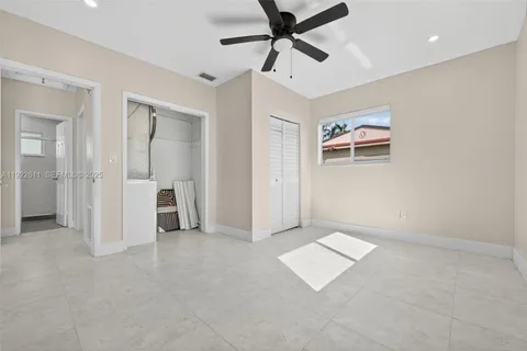an empty room with closet and windows