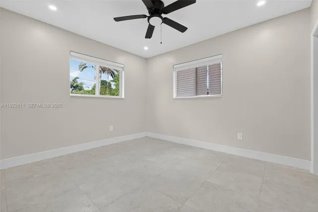 an empty room with a window and a ceiling fan