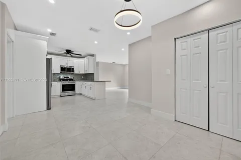 a large white kitchen with stainless steel appliances