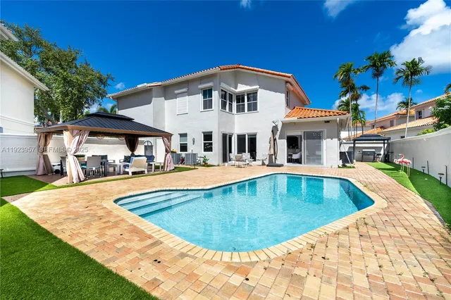 a view of swimming pool with a seating space and a garden view