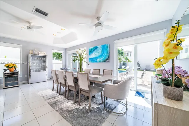 a dining room with furniture a flat screen tv and a potted plant