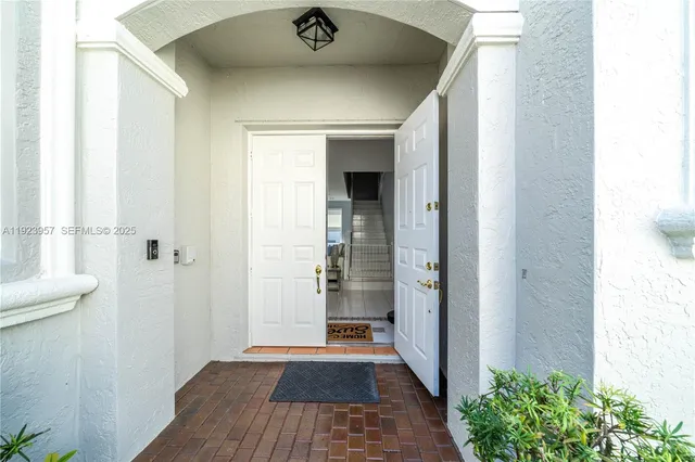 a view of a hallway with wooden floor and a bathroom