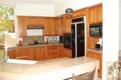 304 Loch Lomond Road Rancho Mirage, CA 92270 - Photo 4 of 17 a kitchen with stainless steel appliances kitchen island granite countertop a refrigerator and a stove top oven