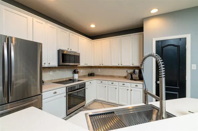 a kitchen with stainless steel appliances a stove a sink and a refrigerator
