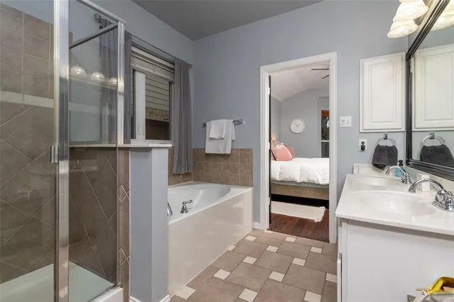 a en suite bathroom with a tub sink and mirror