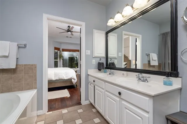 a en suite bathroom with double vanity and a bathtub