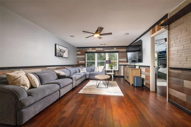 a living room with furniture fireplace and wooden floor