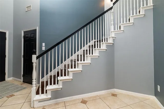 a view of staircase with lots of frames on wall and wooden floor