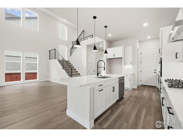 a large white kitchen with wooden floor