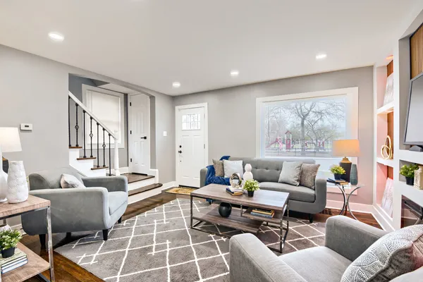 a living room with furniture a rug and a large window