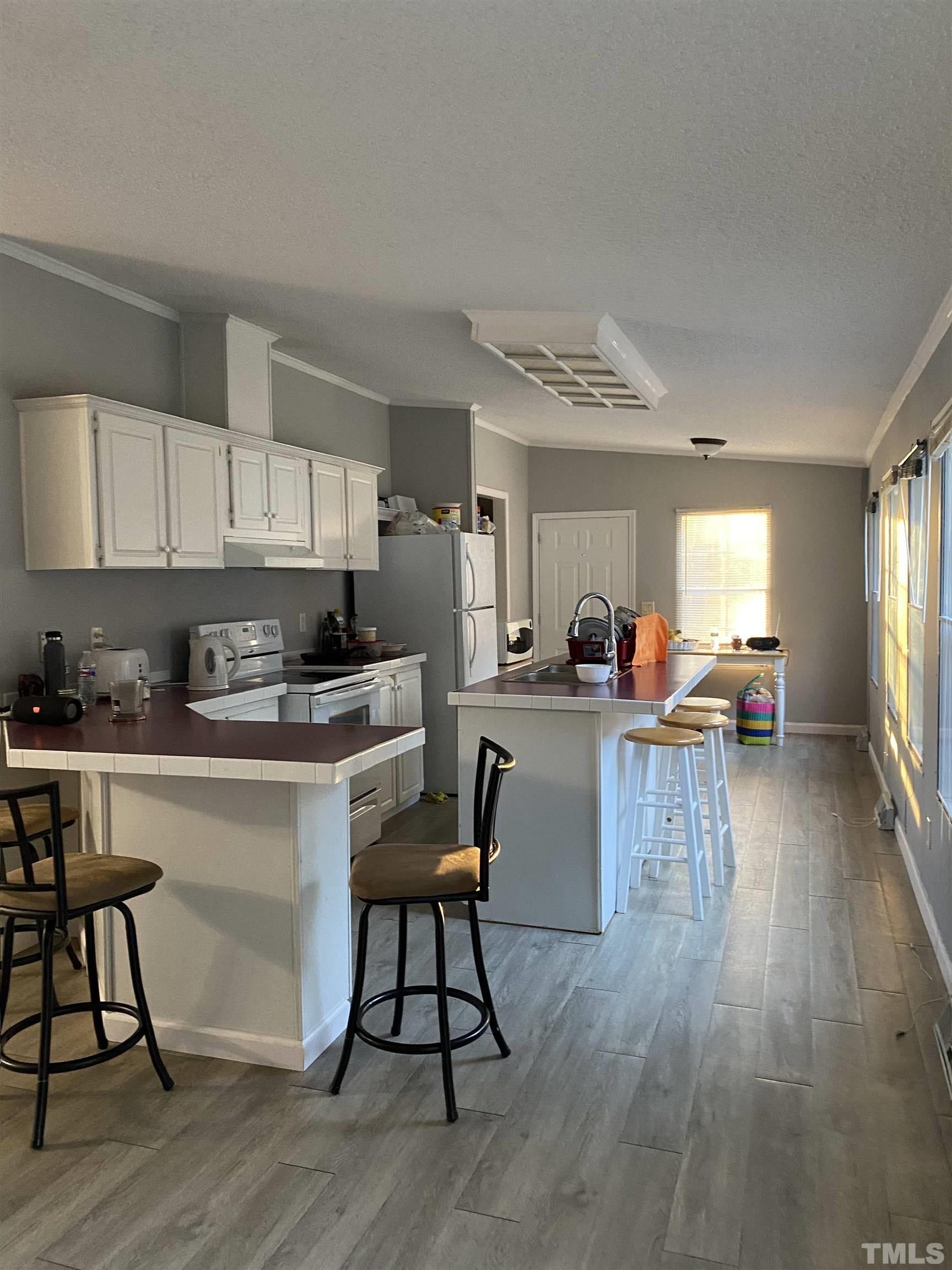 3546 Stagecoach Road Henderson, NC 27537 - Photo 2 of 5 a kitchen with stainless steel appliances granite countertop a stove top oven a sink dishwasher a dining table and chairs with wooden floor