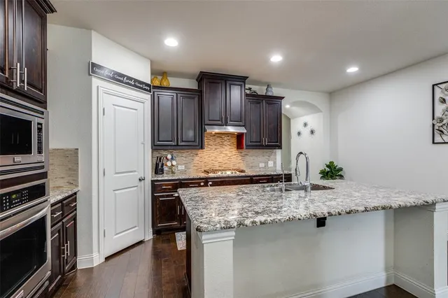 a kitchen with granite countertop stainless steel appliances and wooden cabinets