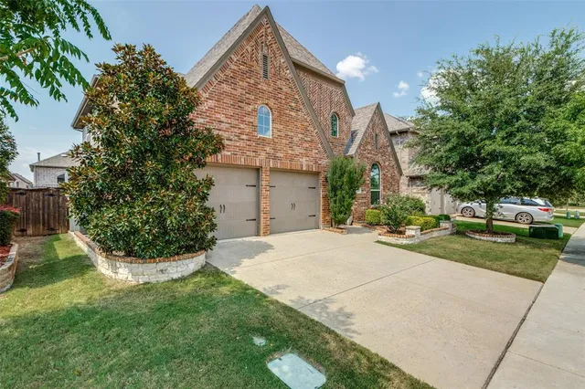 a view of a house with a yard and potted plants