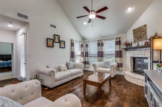 a living room with furniture a fireplace and a chandelier