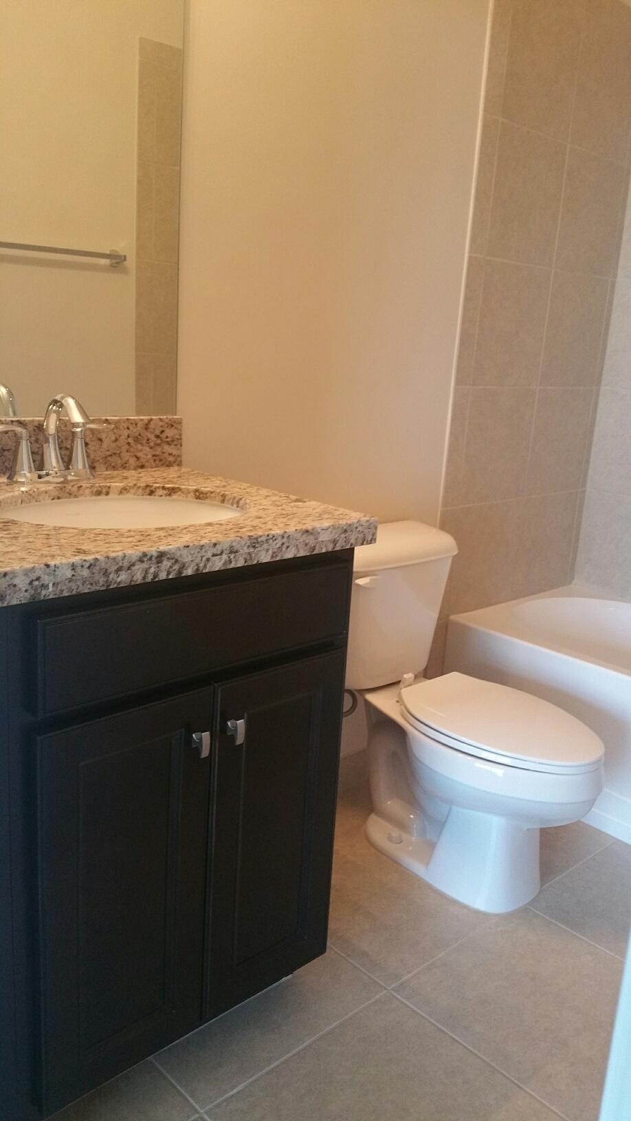 2825 Southwest 119th Way Miramar, FL 33025 - Photo 12 of 23 a bathroom with a granite countertop toilet a sink and a mirror