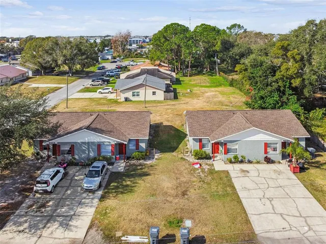 a aerial view of a house with swimming pool and large trees