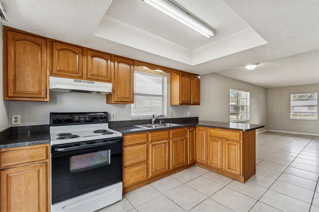 6024 Norton Road Lakeland, FL 33809 - Photo 23 of 56 a kitchen with stainless steel appliances granite countertop a stove sink and cabinets