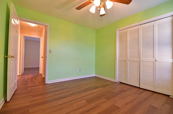 an empty room with wooden floor chandelier and closet