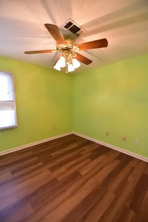 a view of a room with wooden floor and fan