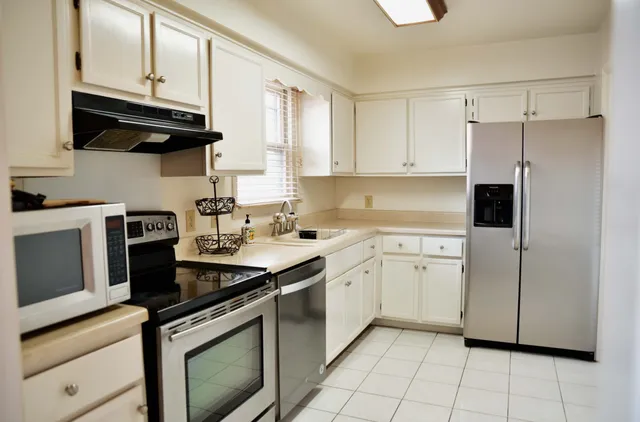 a kitchen with stainless steel appliances granite countertop a stove a sink and a refrigerator