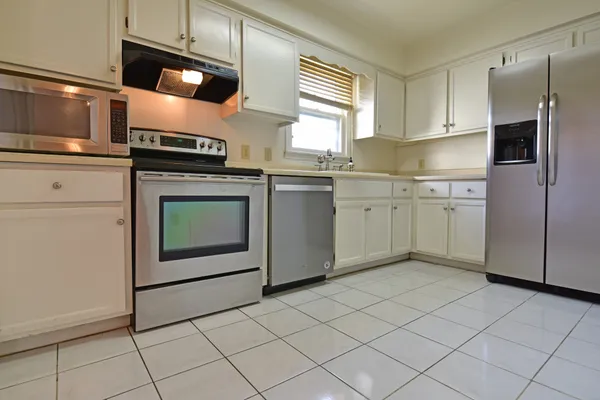 a kitchen with cabinets stainless steel appliances and counter space