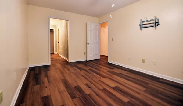 a view of a room with wooden floor and white walls