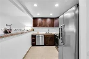 a kitchen with stainless steel appliances granite countertop a refrigerator a sink and a stove