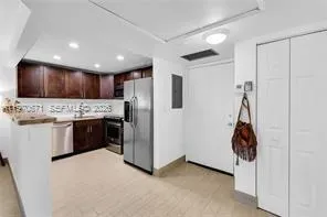 a kitchen with stainless steel appliances kitchen island granite countertop a refrigerator and a stove top oven
