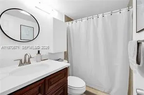 a bathroom with a sink a mirror a toilet and a mirror