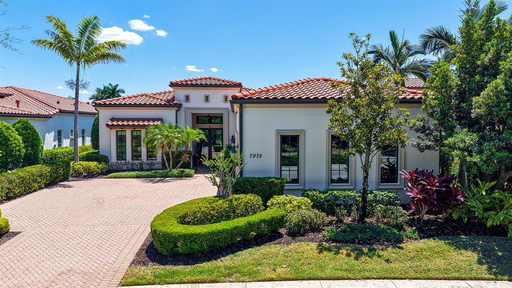 7975 Matera Court Lakewood Ranch, FL 34202 - Photo 11 of 83 a front view of a house with a yard and potted plants