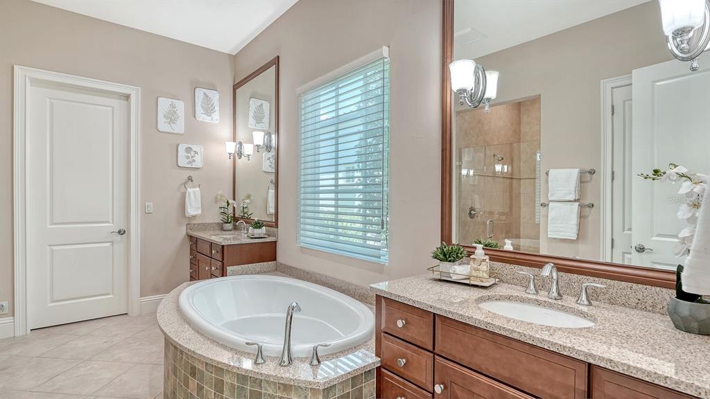 7975 Matera Court Lakewood Ranch, FL 34202 - Photo 30 of 83 a bathroom with a granite countertop sink and a mirror