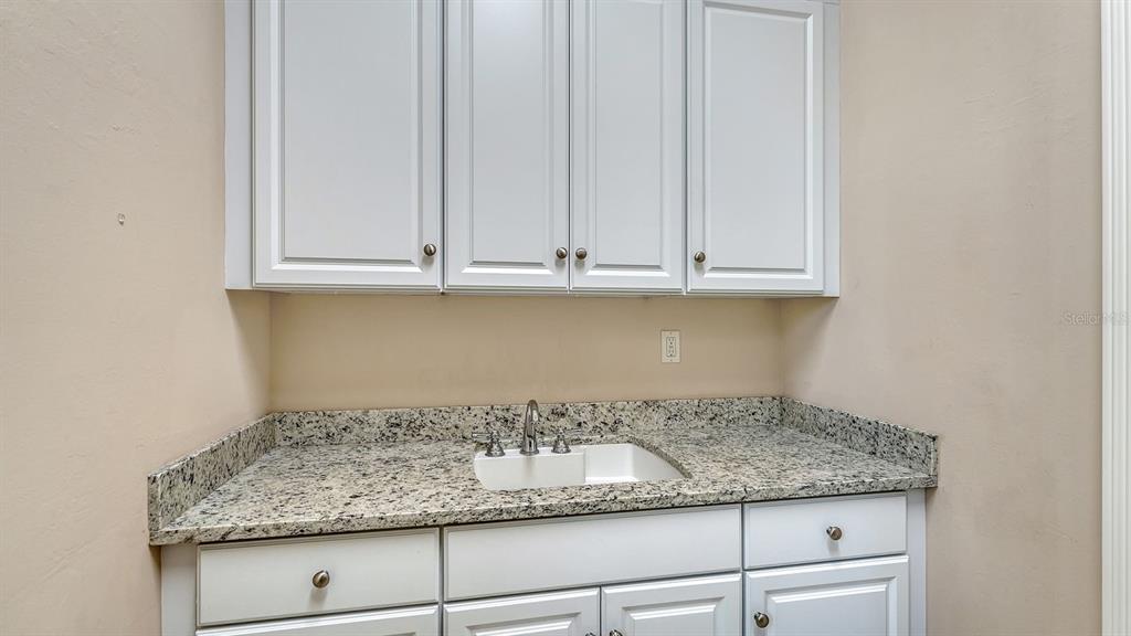 7975 Matera Court Lakewood Ranch, FL 34202 - Photo 42 of 83 a kitchen with granite countertop white cabinets and a white appliances