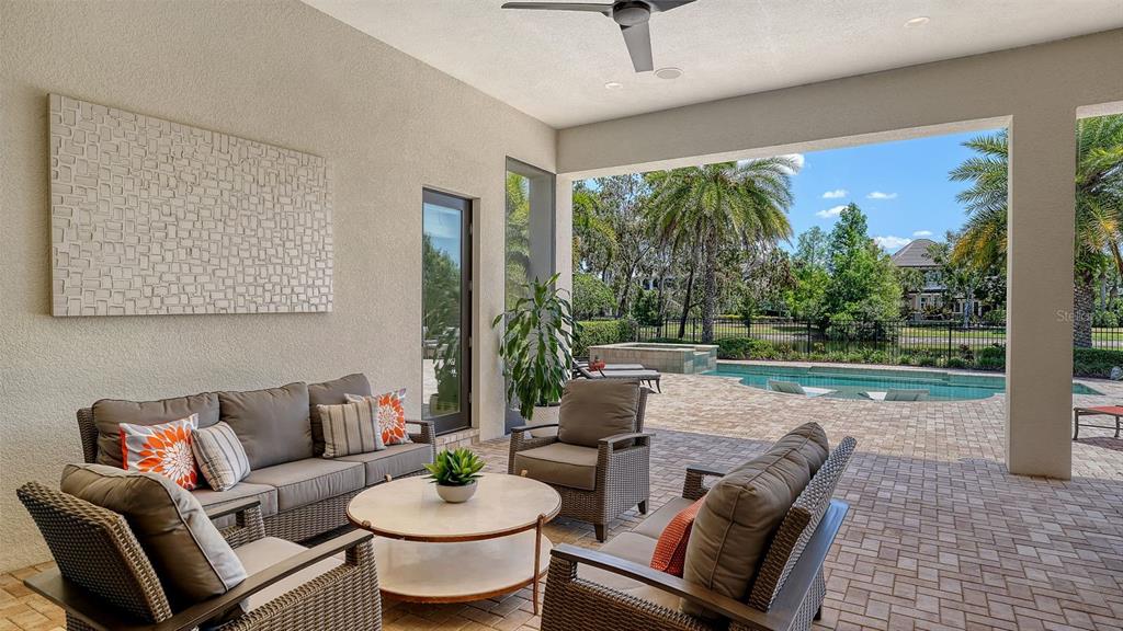 7975 Matera Court Lakewood Ranch, FL 34202 - Photo 43 of 83 a living room with patio furniture and a garden