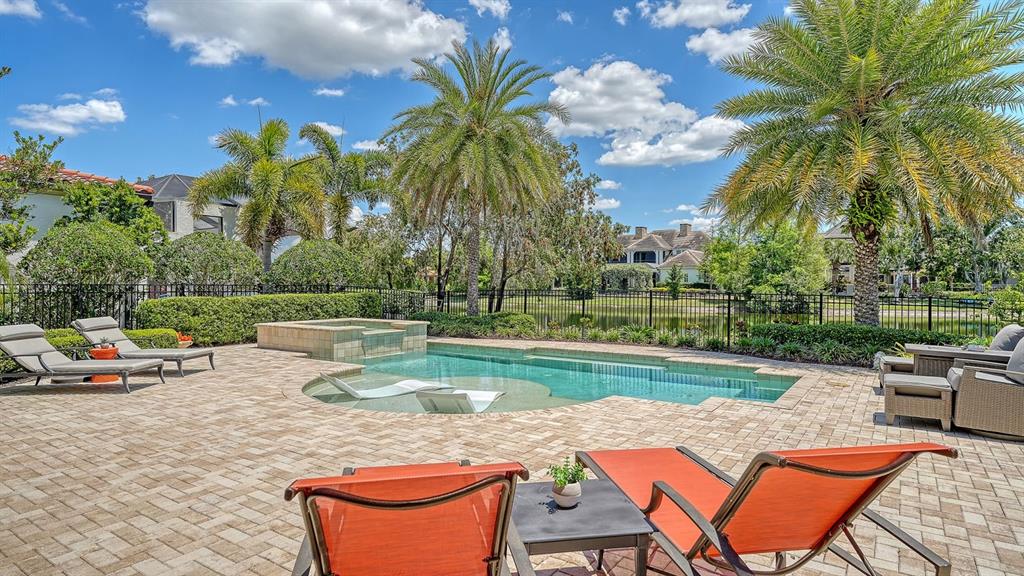 7975 Matera Court Lakewood Ranch, FL 34202 - Photo 48 of 83 a view of a swimming pool with a lounge chair and a lawn chairs