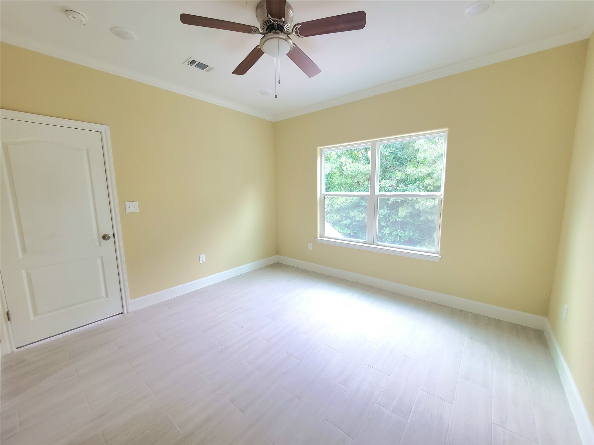 1306 North 9th Street Conroe, TX 77301 - Photo 16 of 47 an empty room with a window and a fan