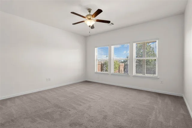 a view of a livingroom with wooden floor and a ceiling fan