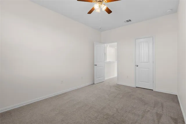 an empty room with a window and a fan